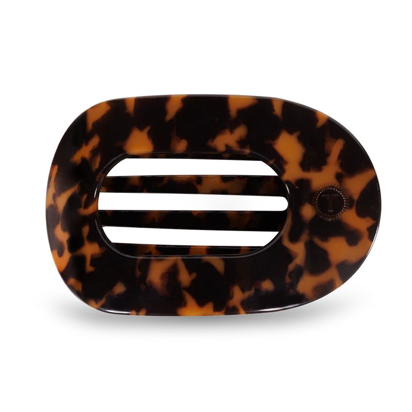 A flat round hair clip with a tortoise pattern design.