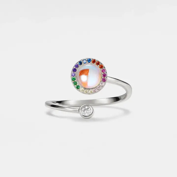 Silver ring with a colorful gemstone on a light gray background