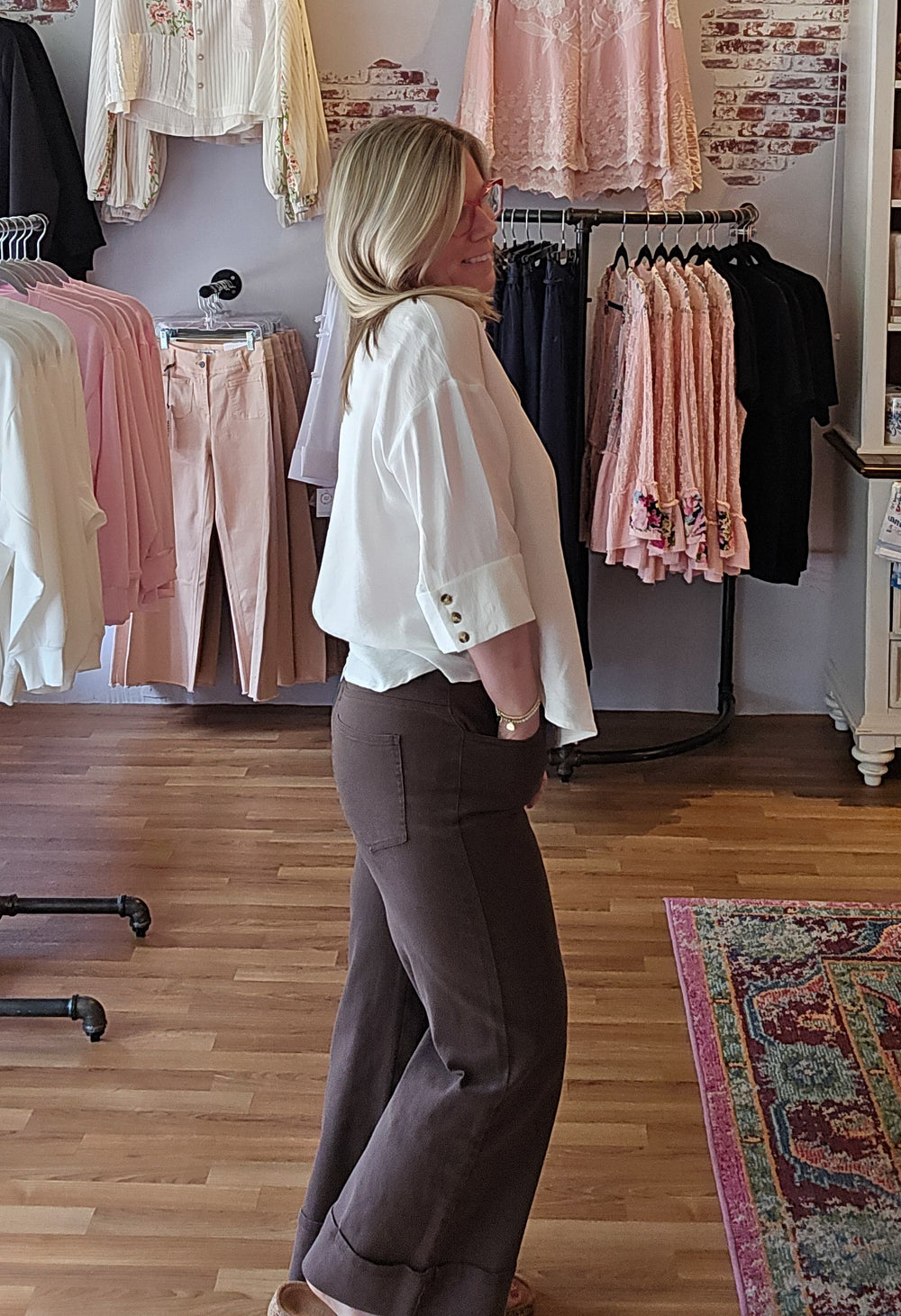 Woman in a clothing store looking at clothes on racks.