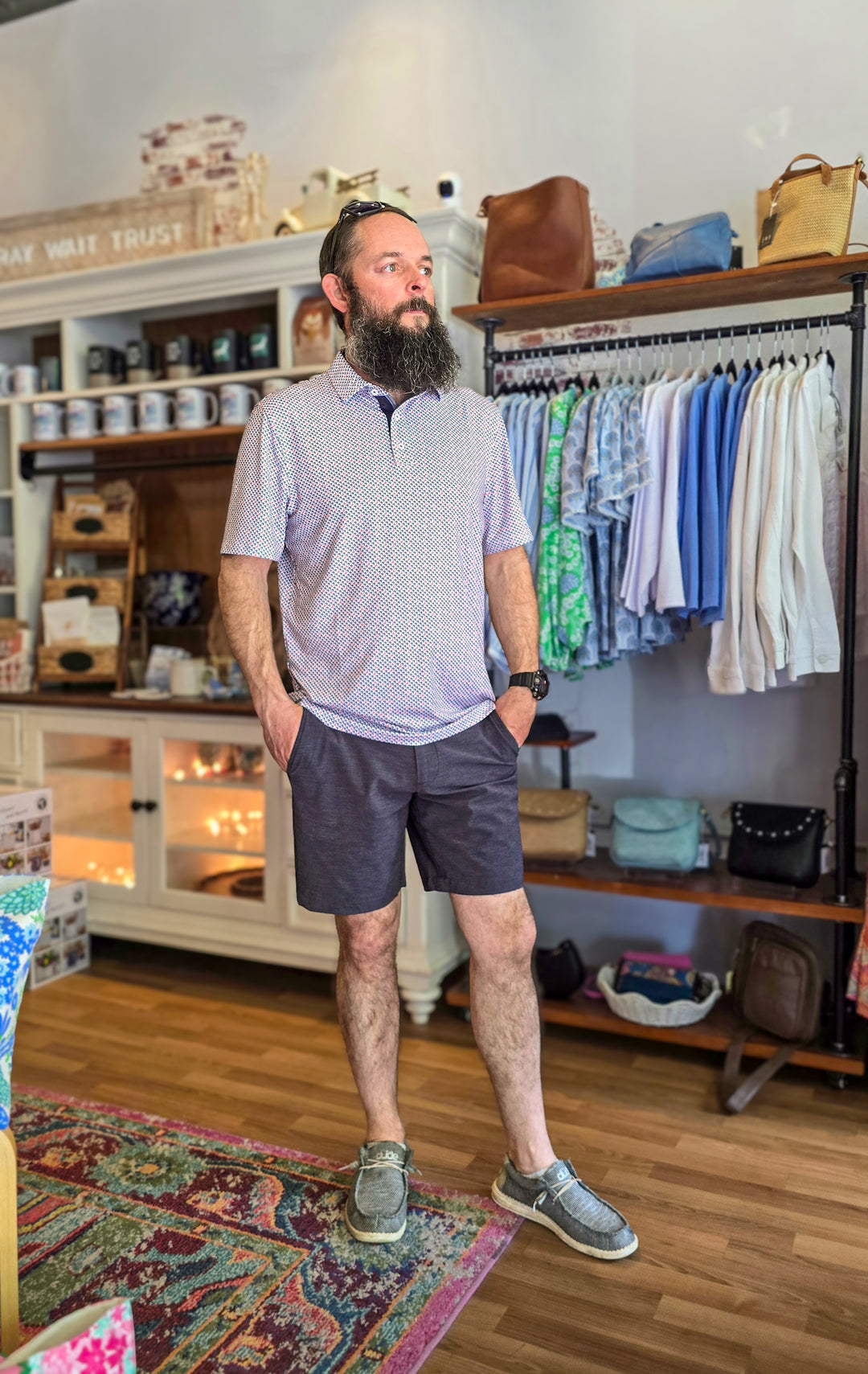 Man with a beard standing in a clothing store