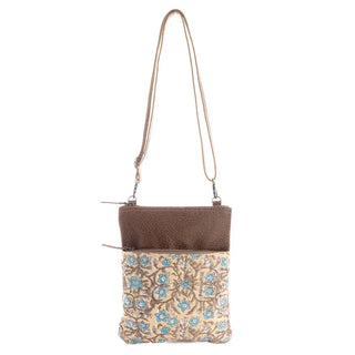 Crossbody bag with floral pattern and brown top section on a white background