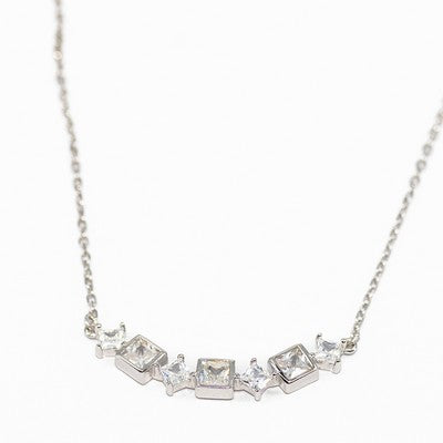 Silver necklace with square-cut gemstones on a white background