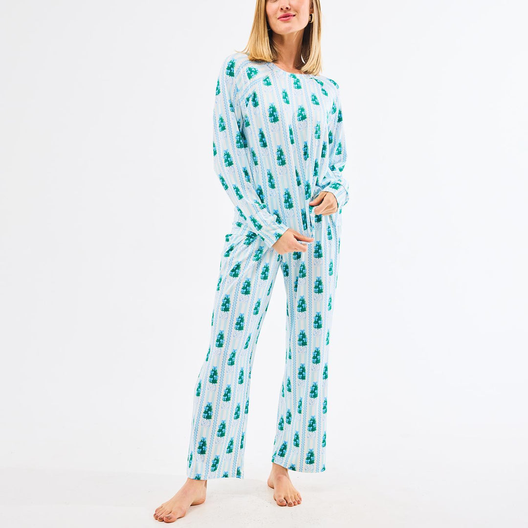 Woman wearing a teal and white patterned pajama set on a white background