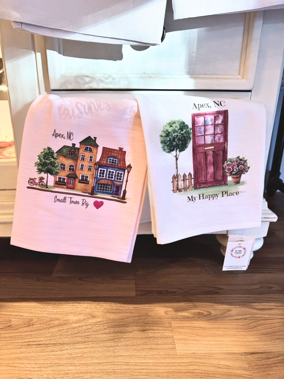 Two towels with printed designs hanging on a rack.