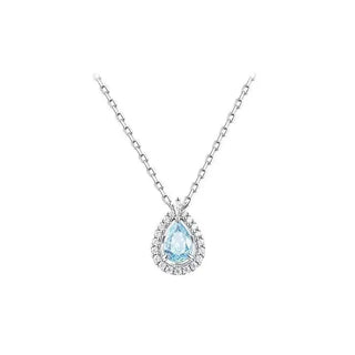 A silver-toned pendant necklace featuring a teardrop-shaped light blue gemstone surrounded by a halo of small clear stones, suspended from a delicate silver chain against a plain white background.