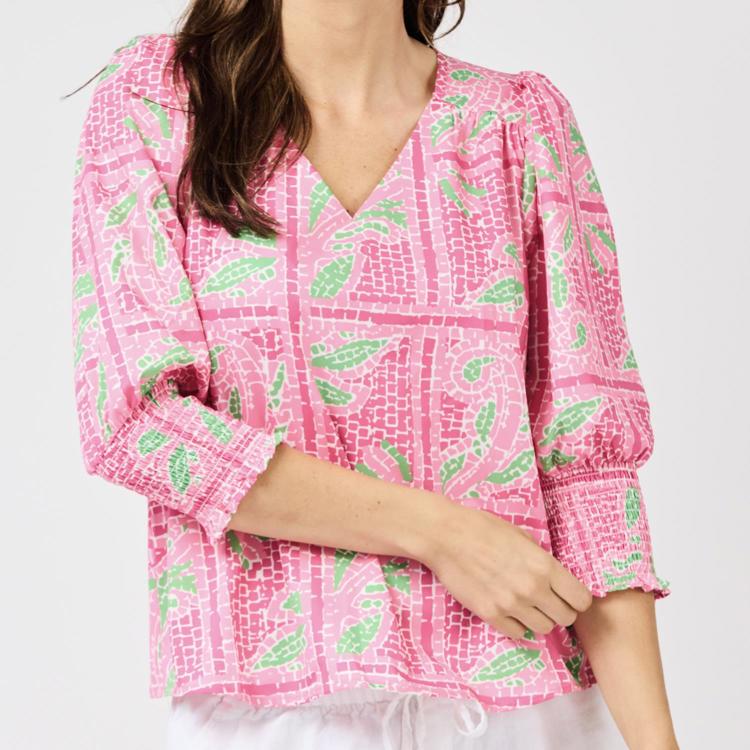Pink patterned blouse with long sleeves on a white background
