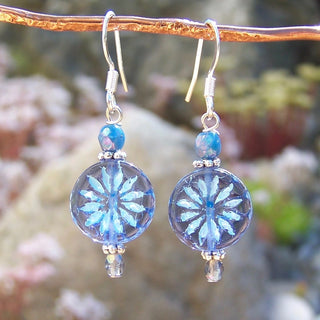 blue aster star dangle earrings with stainless steel hooks and beads hanging on a branch
