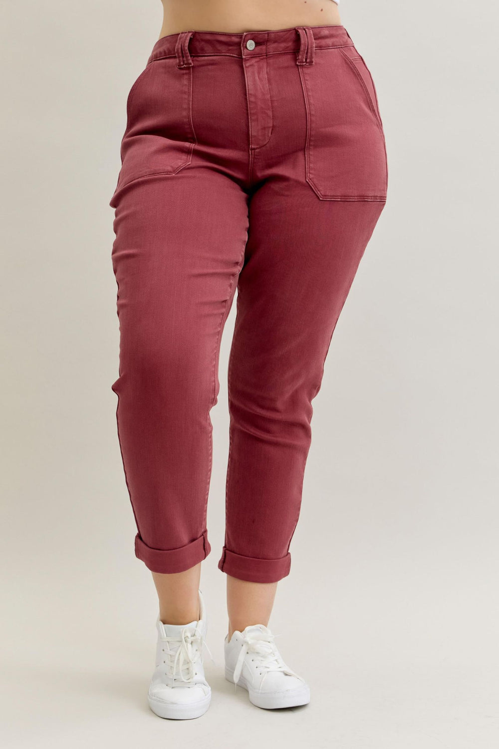 Maroon pants worn by a person on a beige background