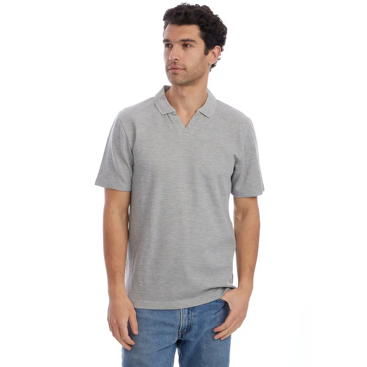 Man wearing a gray polo shirt and blue jeans on a white background