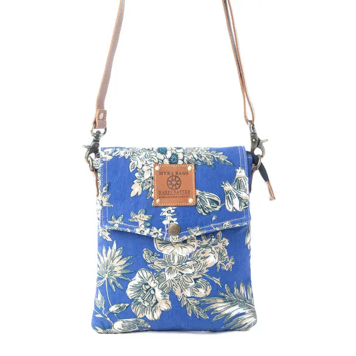 Blue floral-patterned crossbody bag with a visible brand label on a white background