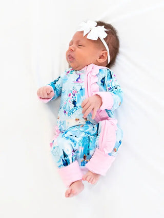 baby wearing blue onesie with princess and castle pattern