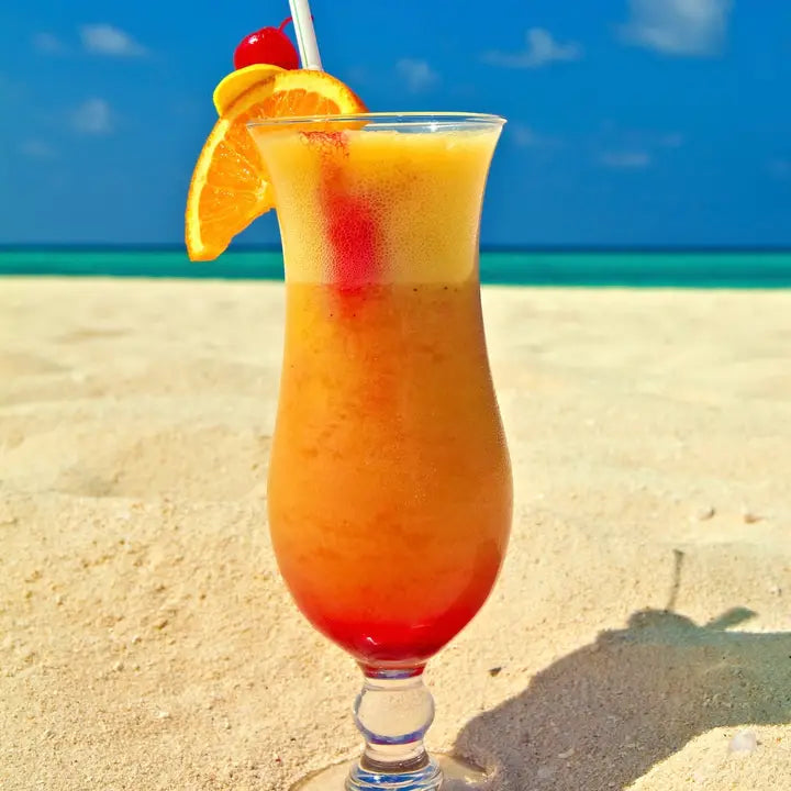 orange drink in a glass on a beach