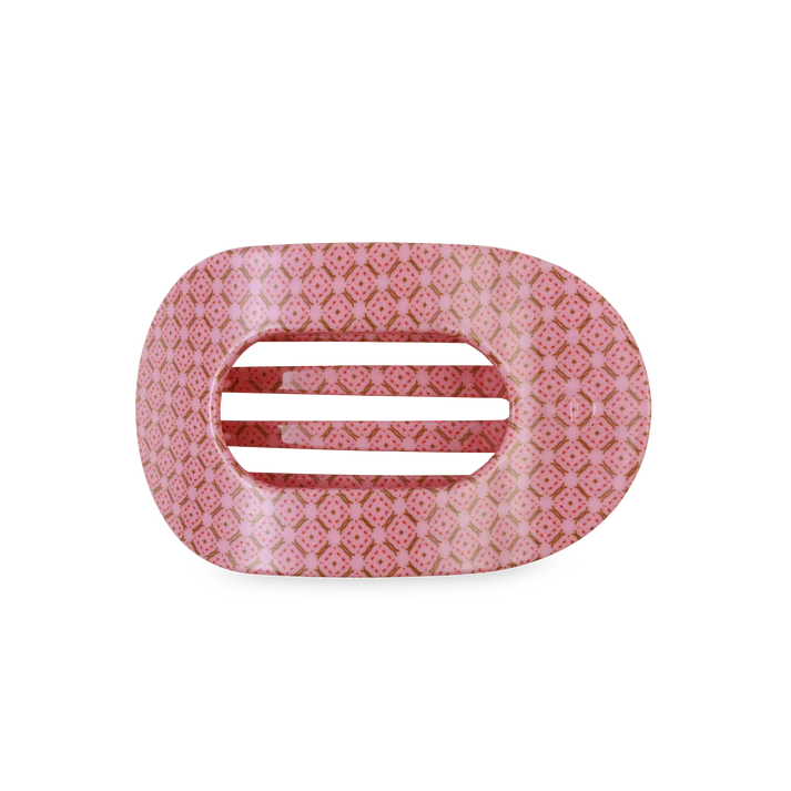 Pink hair clip with a subtle pattern on a white background