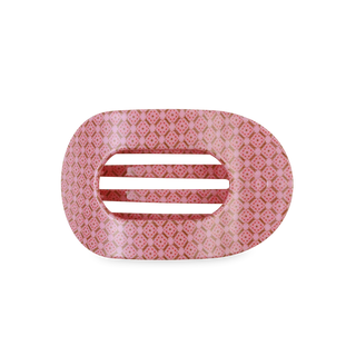 Pink hair clip with a subtle pattern on a white background