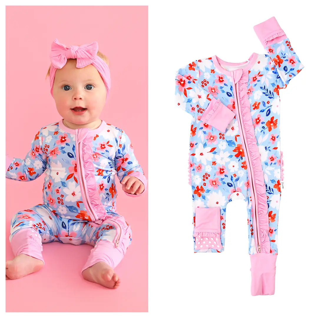 Baby outfit with floral pattern and pink accents on a pink background