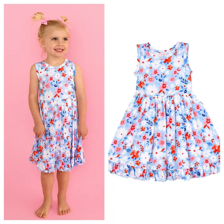 Child wearing a floral dress with a pink background