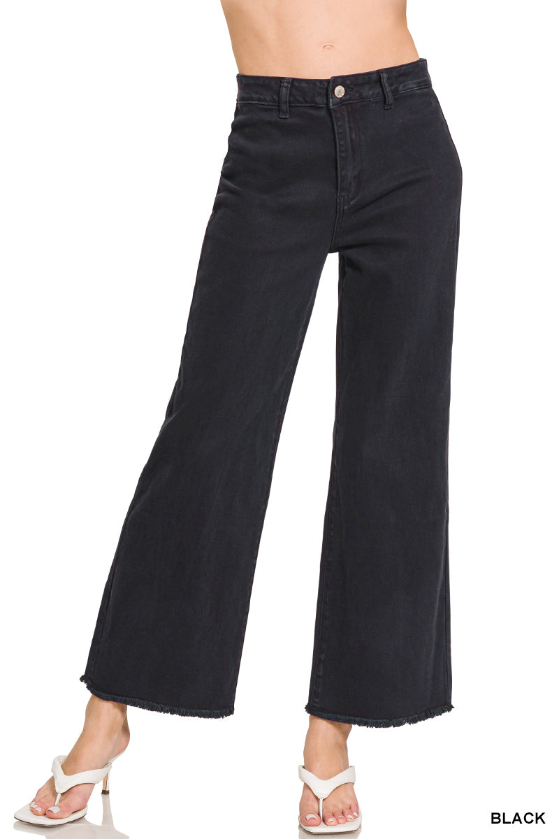 Black wide-leg jeans worn by a person on a white background