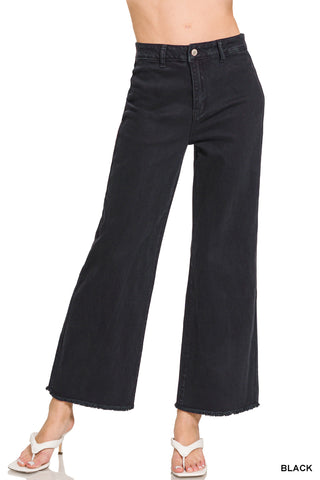 Black wide-leg jeans worn by a person on a white background
