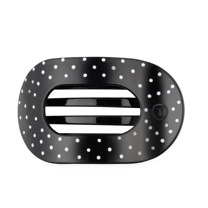 black oval shaped hair clip with white polka dots