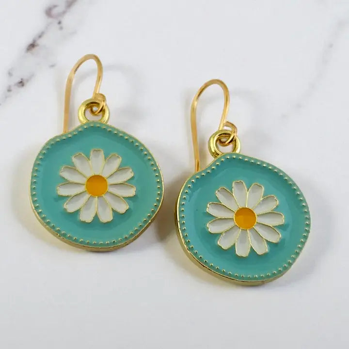 Pair of earrings with daisy design on a light background