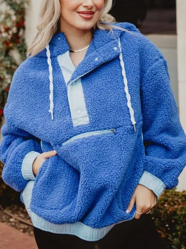 Person wearing a blue fleece jacket with a hood outdoors