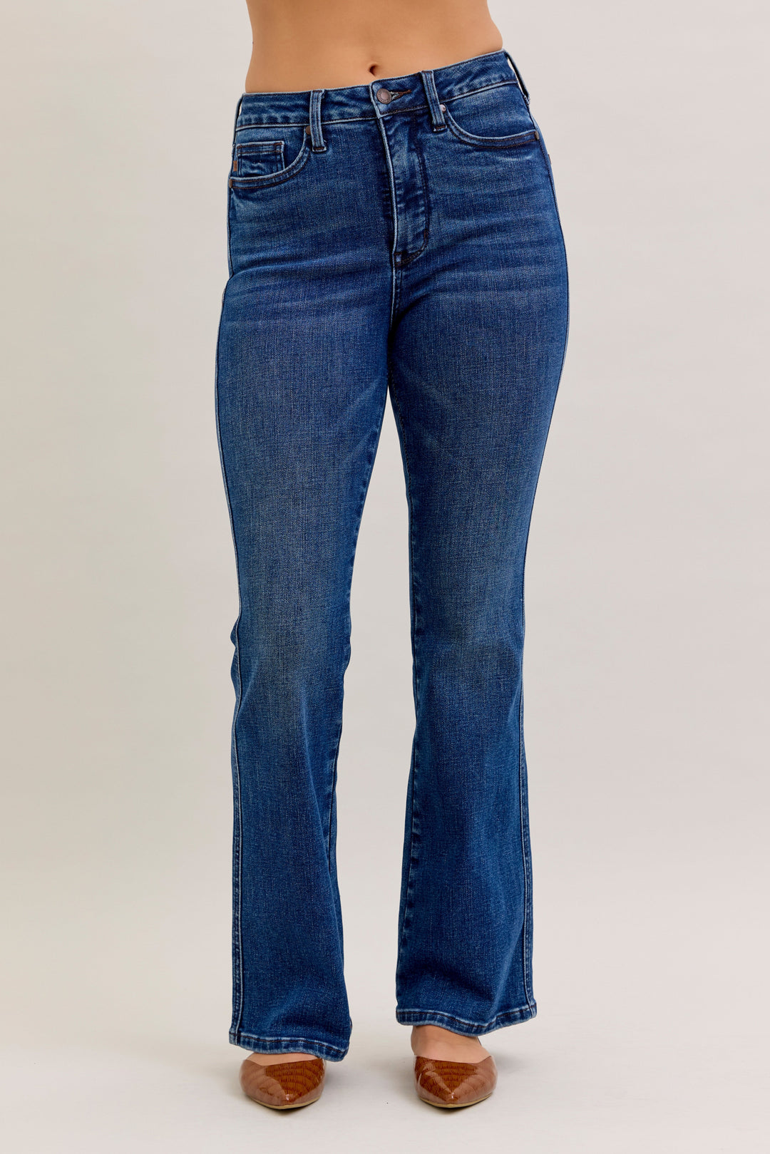 Blue jeans worn by a person on a plain background