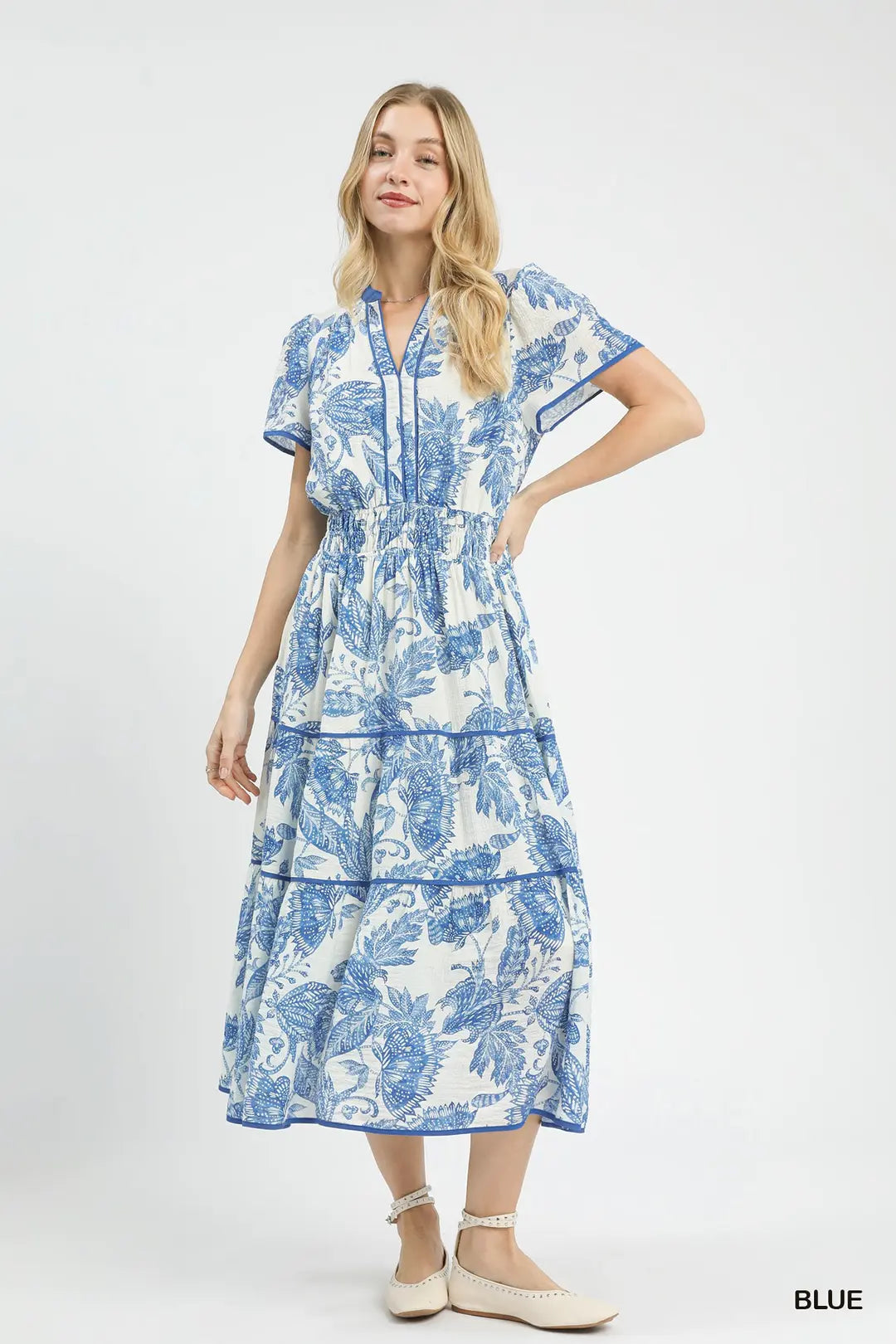 Woman wearing a blue and white floral dress on a white background