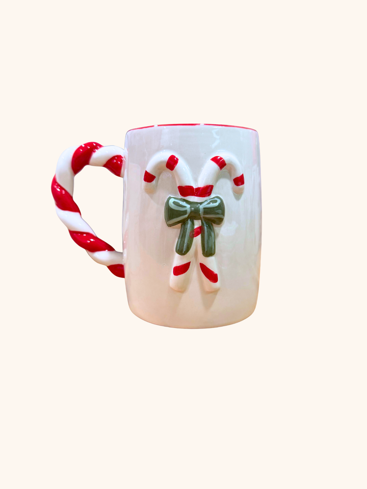 White mug with candy cane handles and a bow on a white background