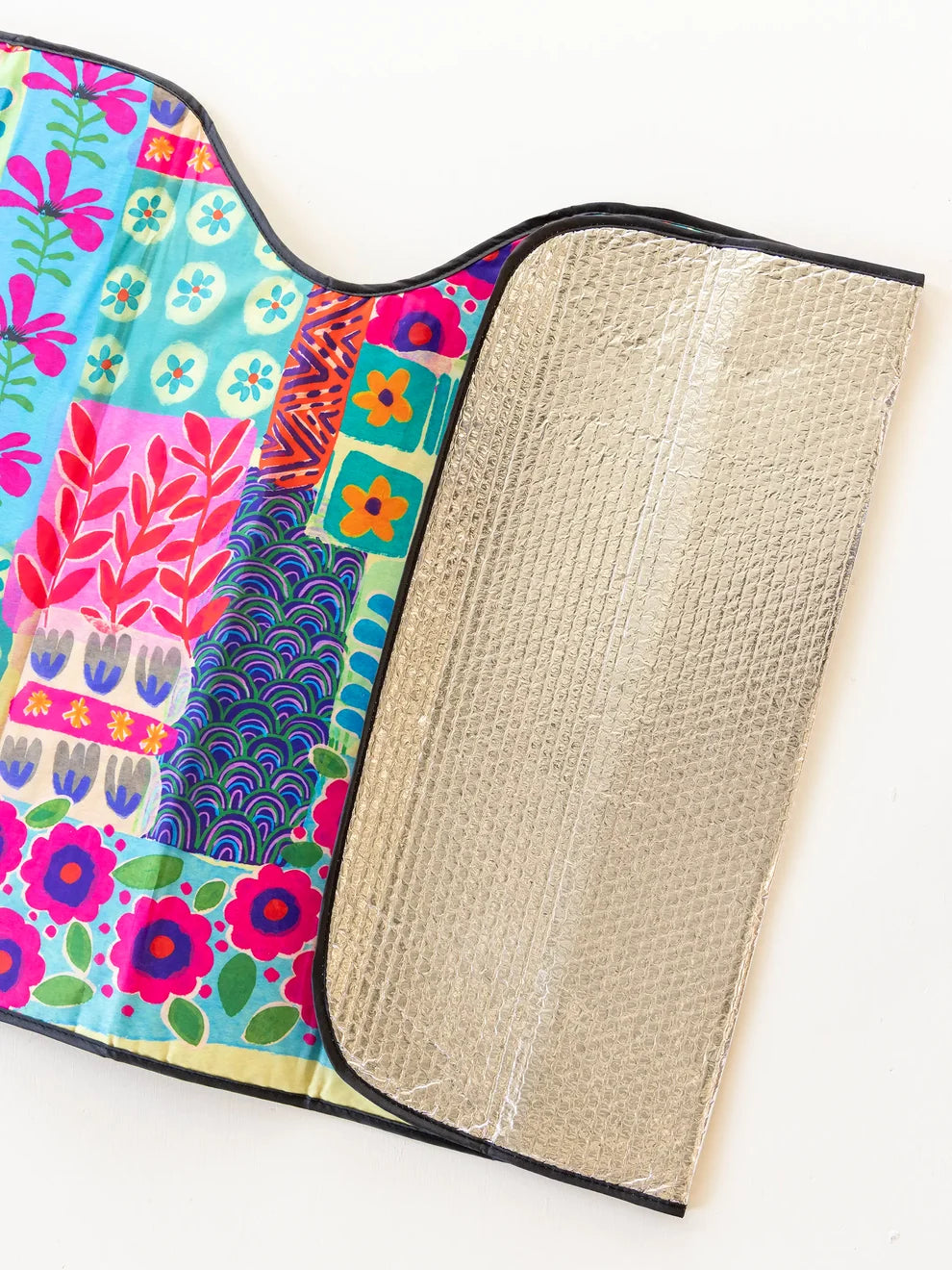 Colorful fabric with floral patterns and a textured beige lining on a white background