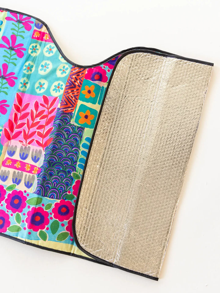 Colorful fabric with floral patterns and a textured beige lining on a white background