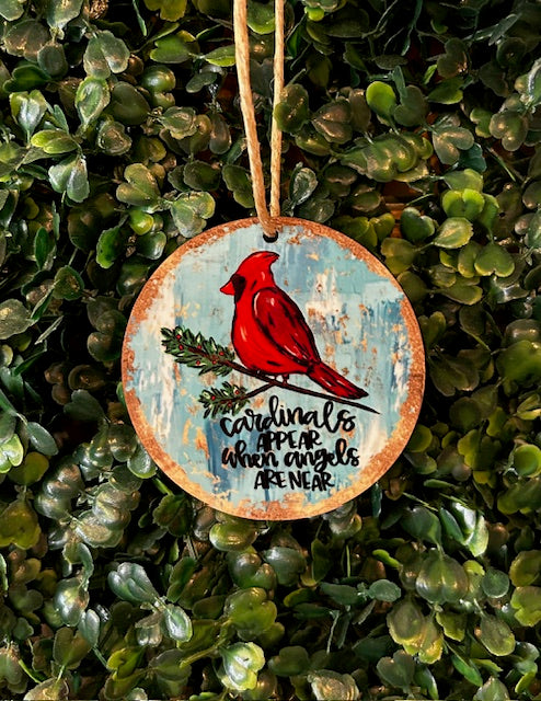 Decorative ornament with a red cardinal and text on a green leaf background