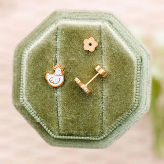 green jewelry holder with white chicken earrings with gold accents