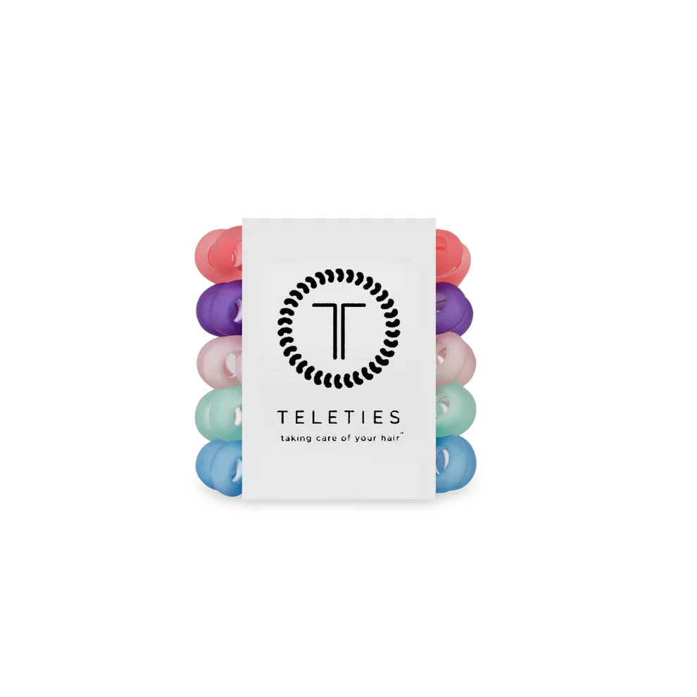 Stack of colorful hair ties with a Teleties branded card on a white background