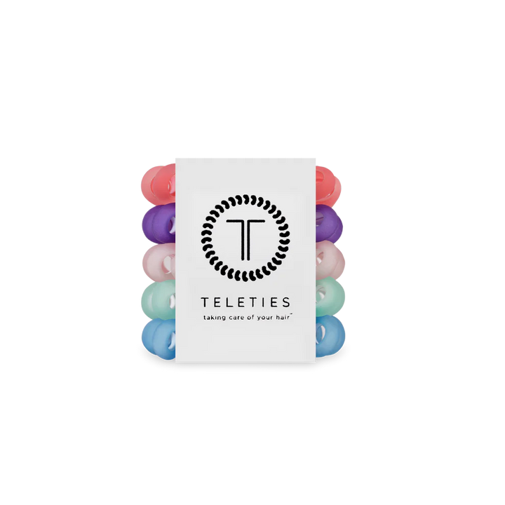 Stack of colorful hair ties with a Teleties branded card on a white background