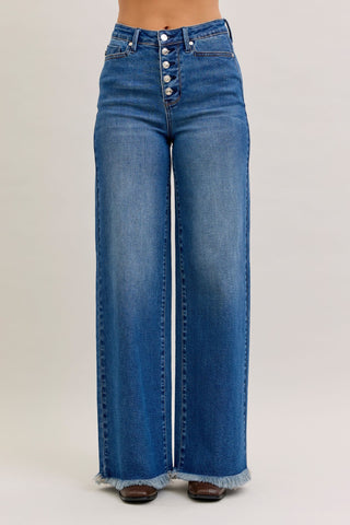 Blue jeans with a button fly on a plain background