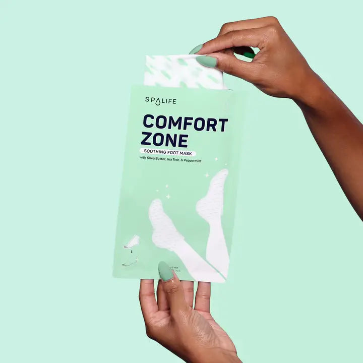 Spa Life Comfort Zone foot mask packaging held by a hand against a light green background