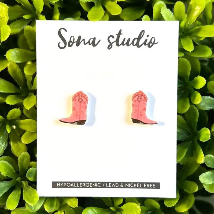 Card with pink cowboy boot earrings on a green leafy background, featuring 'Sona Studio' branding.