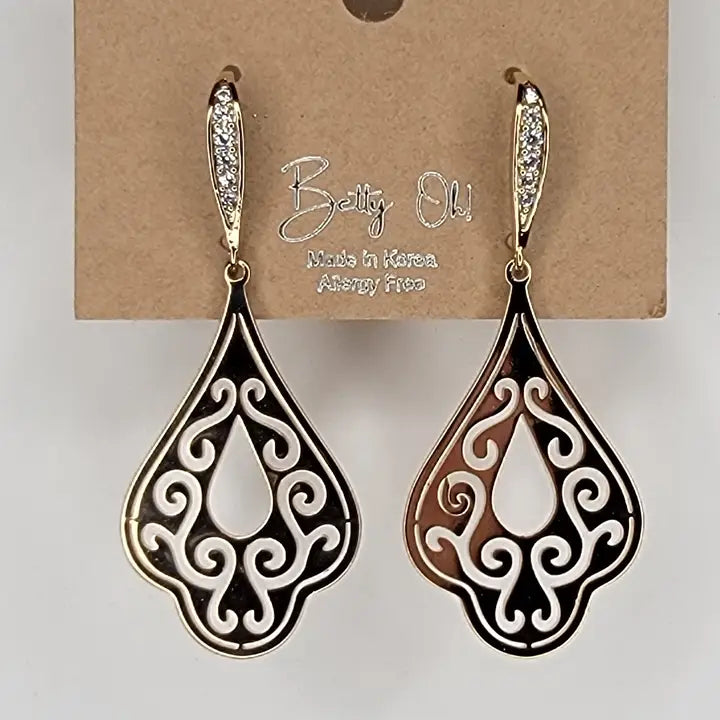 Pair of ornate teardrop earrings on a Betty Olu branded card.