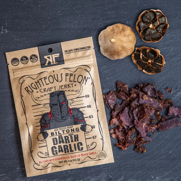 Righteous Felon craft jerky package with garlic bulbs on a dark surface