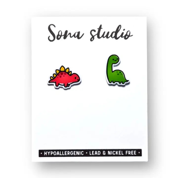 Two dinosaur-shaped pins on a white card with 'Sona studio' branding.
