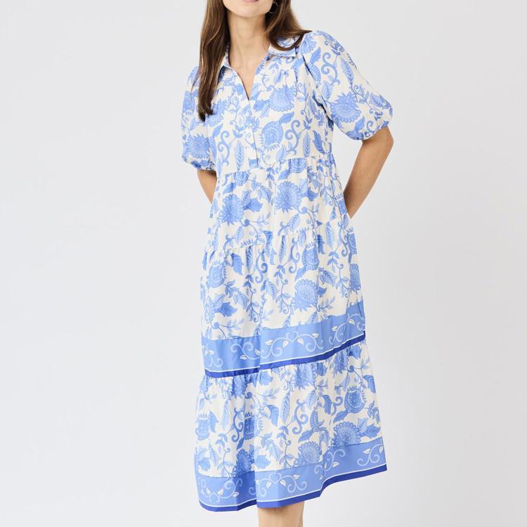 Woman wearing a blue and white floral dress on a white background