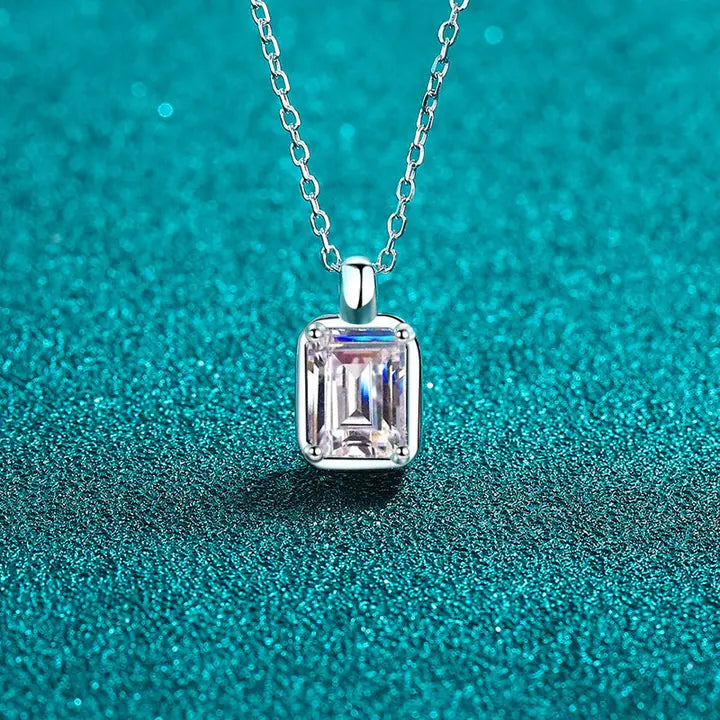 Silver necklace with a rectangular diamond pendant on a teal background