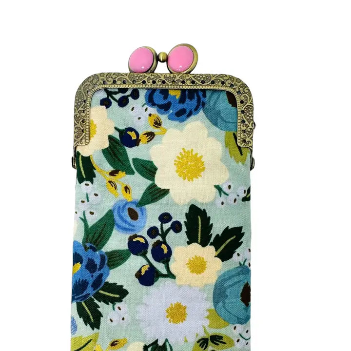 Floral patterned pouch with decorative clasp on a white background