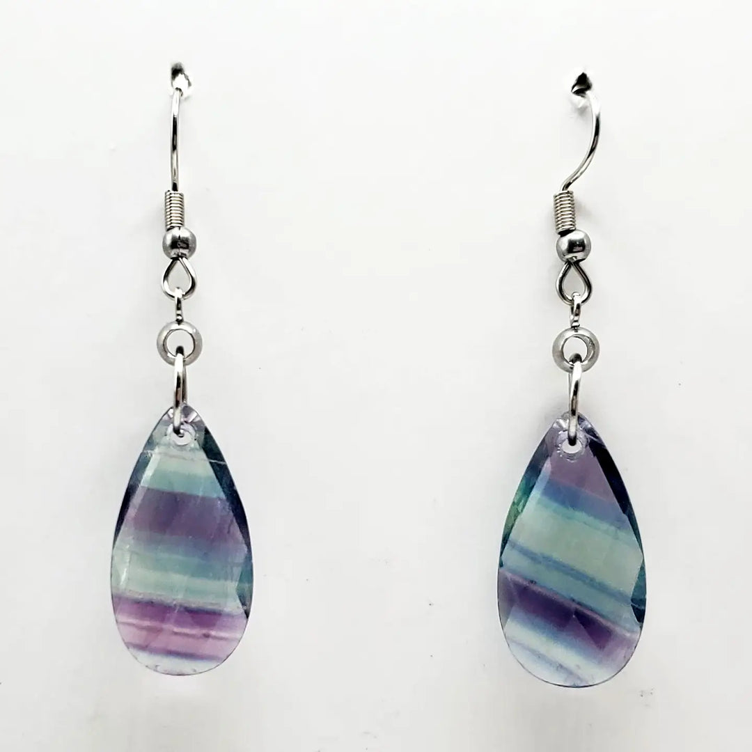 Teardrop-shaped earrings with multicolored stones on a white background