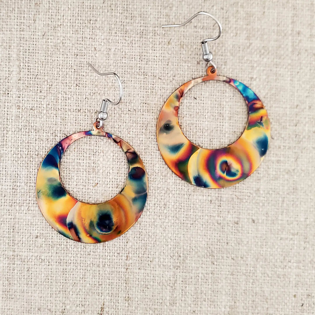 Colorful hoop earrings on a textured beige background
