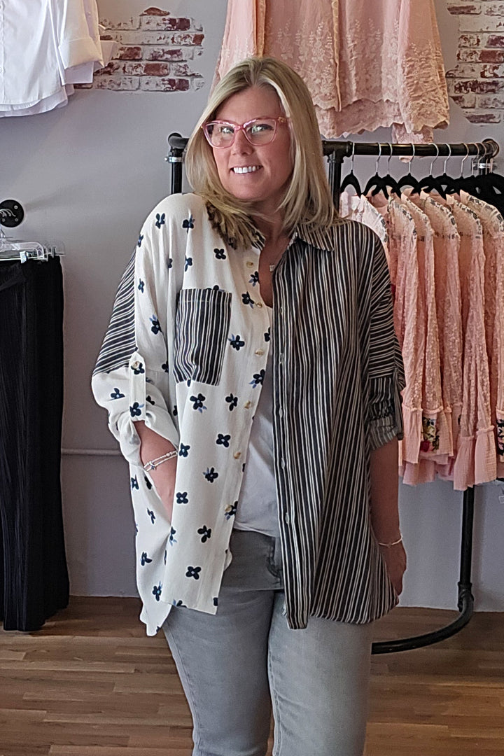 Woman standing in a clothing store with racks of clothes in the background