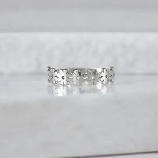 Silver floral ring on a light gray background