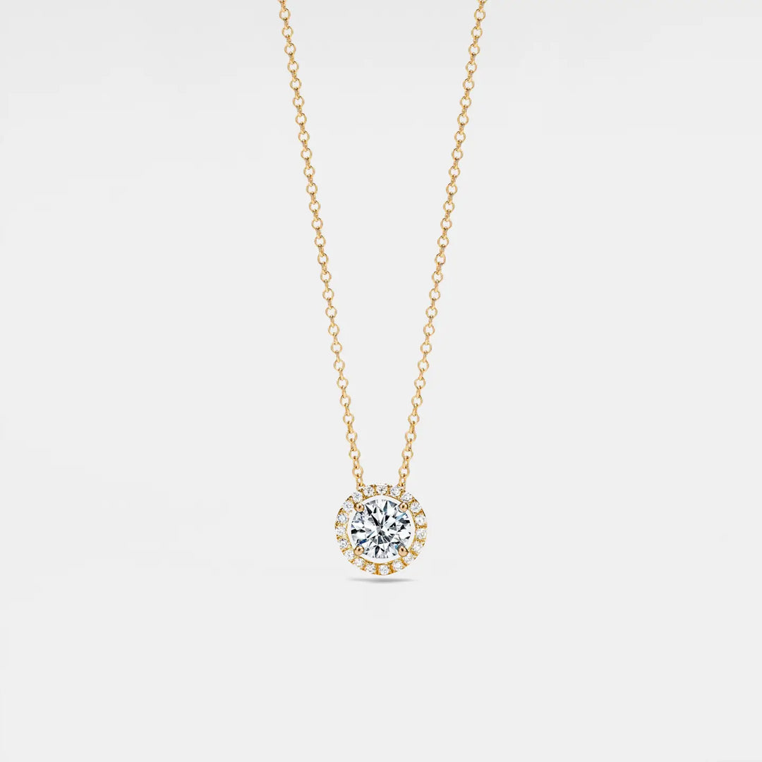 Gold necklace with a diamond pendant on a light gray background