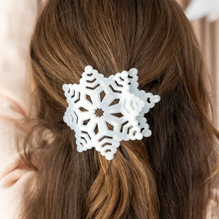 girl with brown hair wearing a white sparkly snowflake shaped flat hair clip