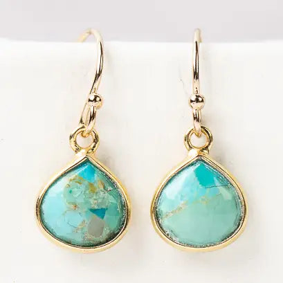 Turquoise teardrop earrings with gold frames on a white background